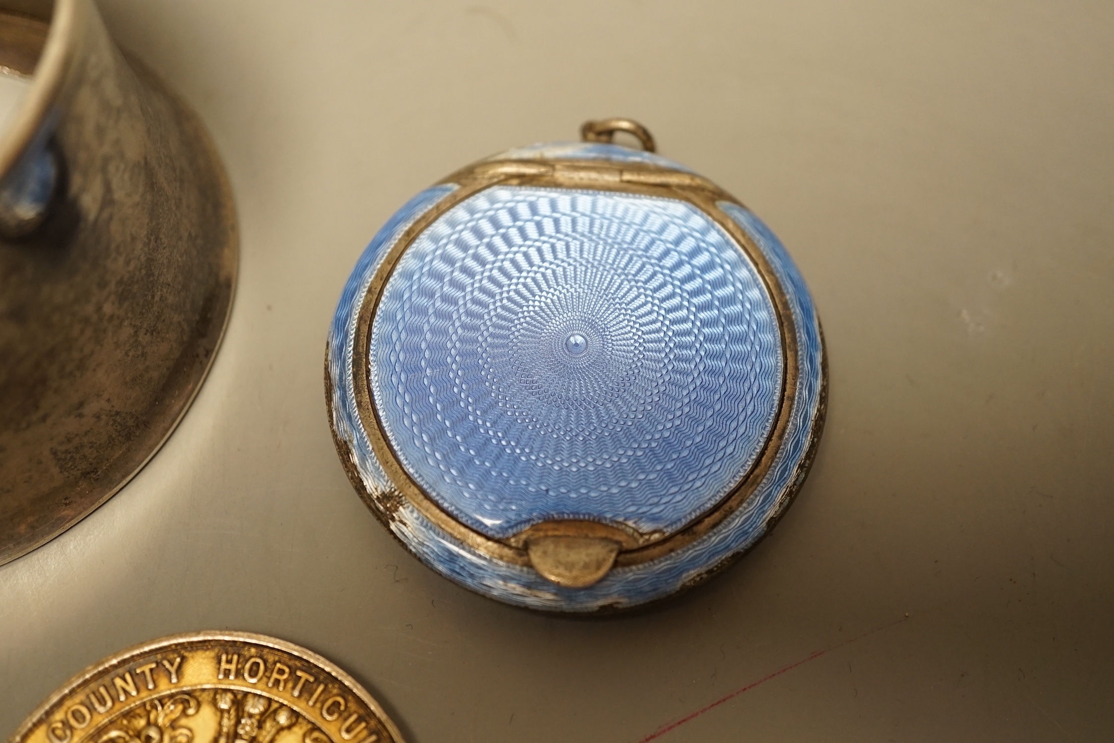 A George V silver cup holder, Birmingham, 1918, a silver and enamel Cardiff & County Horticultural Society medallion and a silver and enamel compact(a.f.)